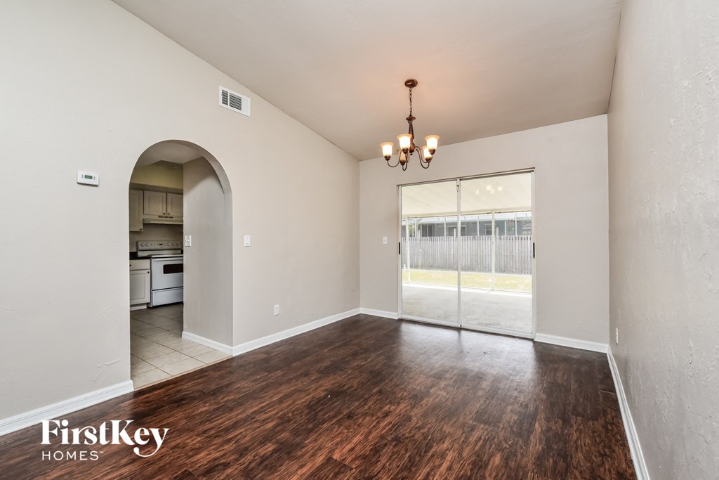 A room with wooden floors and a chandelier.