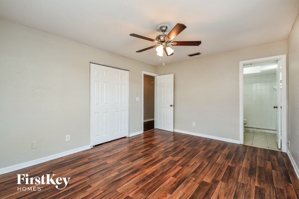 A room with wooden floors and a ceiling fan.