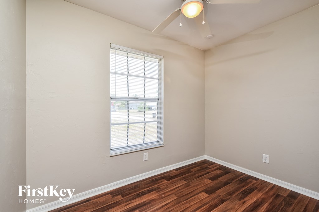 A room with a window and wooden flooring.