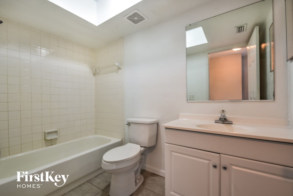 A white bathroom with a toilet, sink, and bathtub.