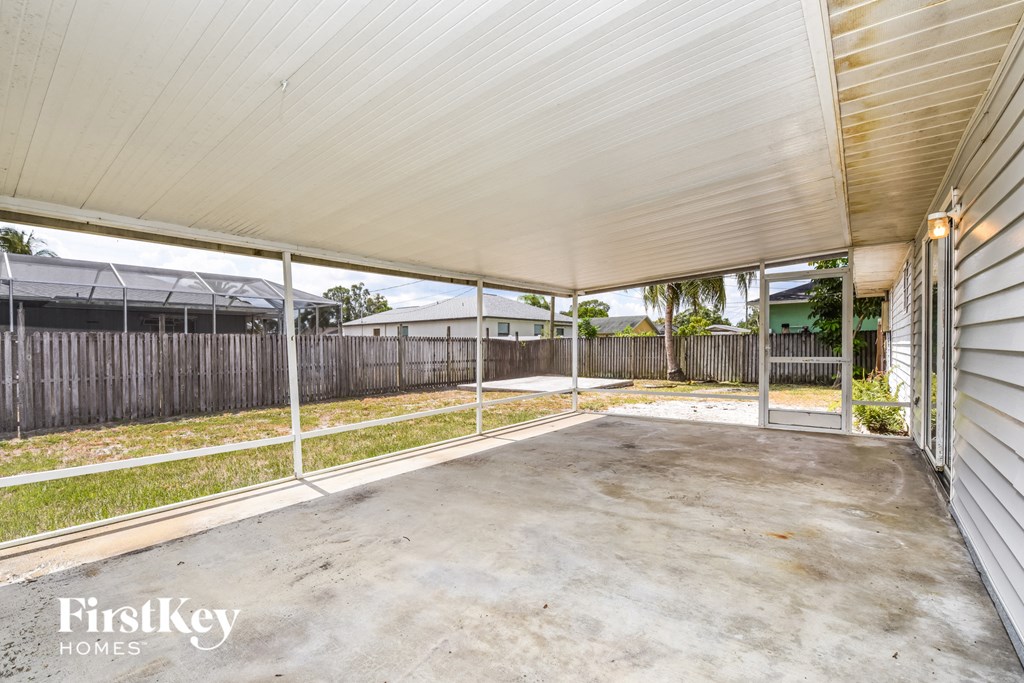 A patio area with a white roof and a white fence.