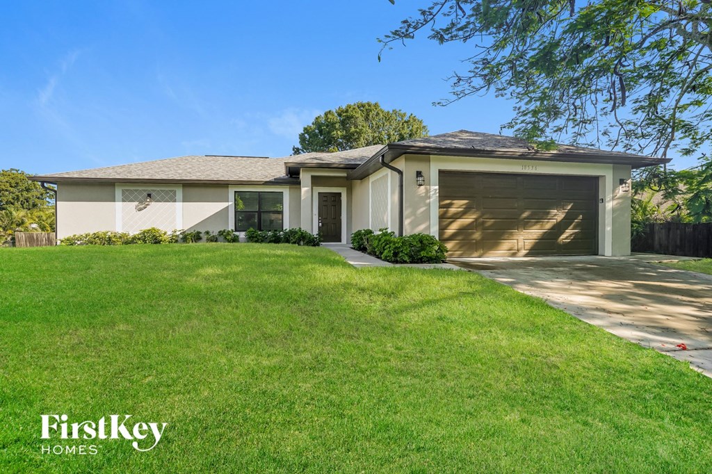 A house with a garage and a driveway in front of it.