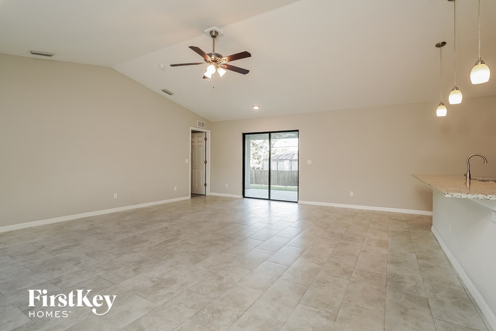 A spacious room with a ceiling fan and a marble countertop.
