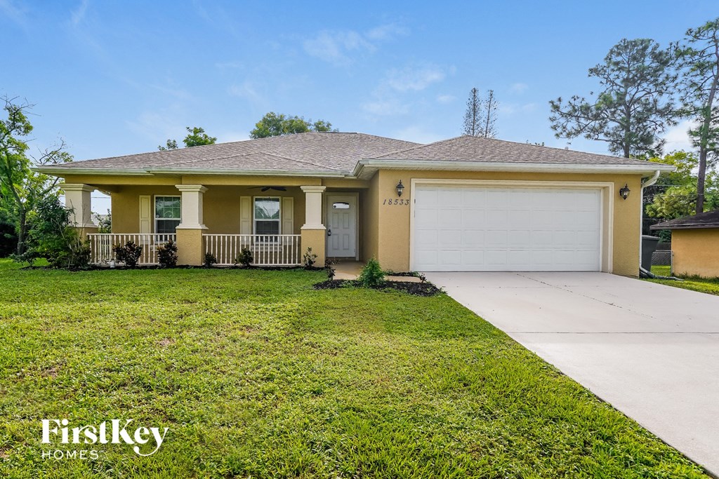 a yellow house with a lawn and a white garage door