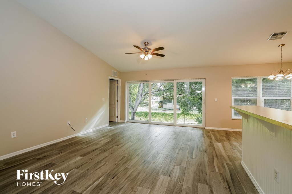 a living room with a ceiling fan and a large window