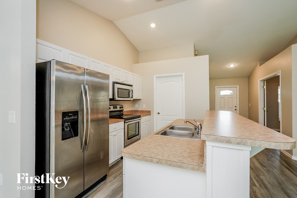 a kitchen with stainless steel appliances and white cabinets