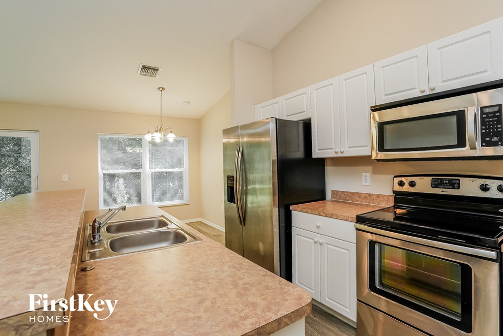 a kitchen with stainless steel appliances and white cabinets