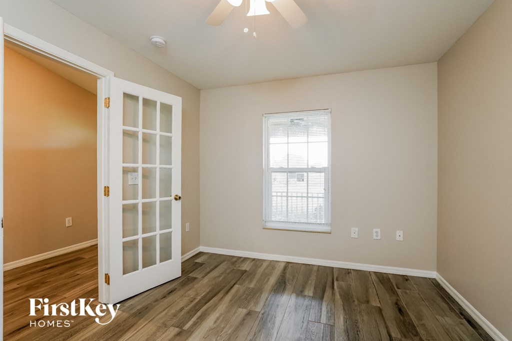 the living room of an empty house with a white door and a window