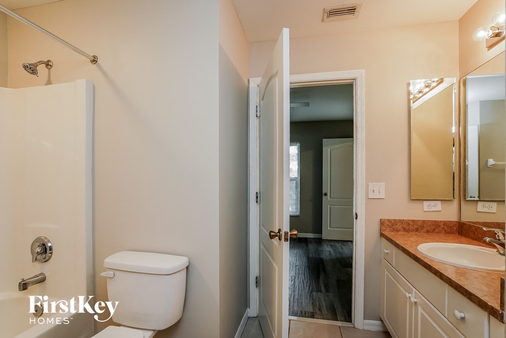 a bathroom with a toilet and a sink and a mirror