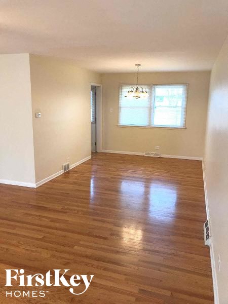 an empty living room with a hard wood floor