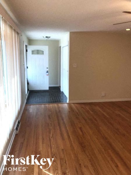 a empty living room with wood floors and a white door