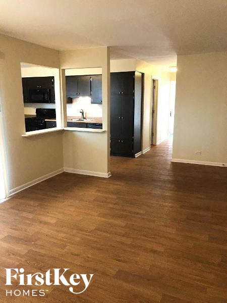 an empty living room and kitchen with a wood floor