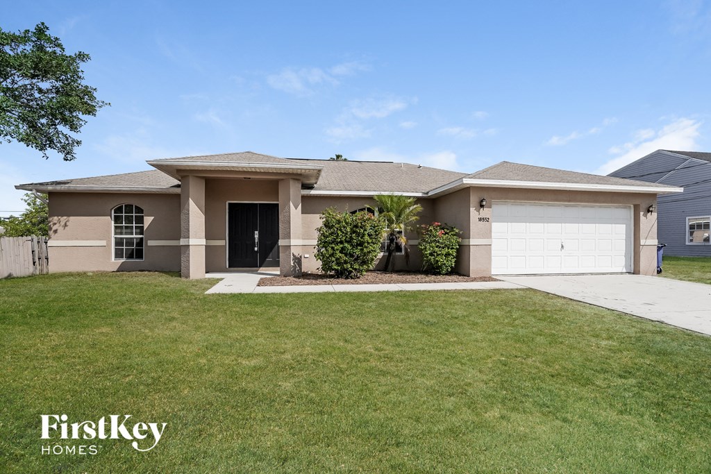 A house with a well-maintained lawn and a clear sky above.