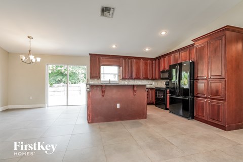 A kitchen with wooden cabinets and a red island.