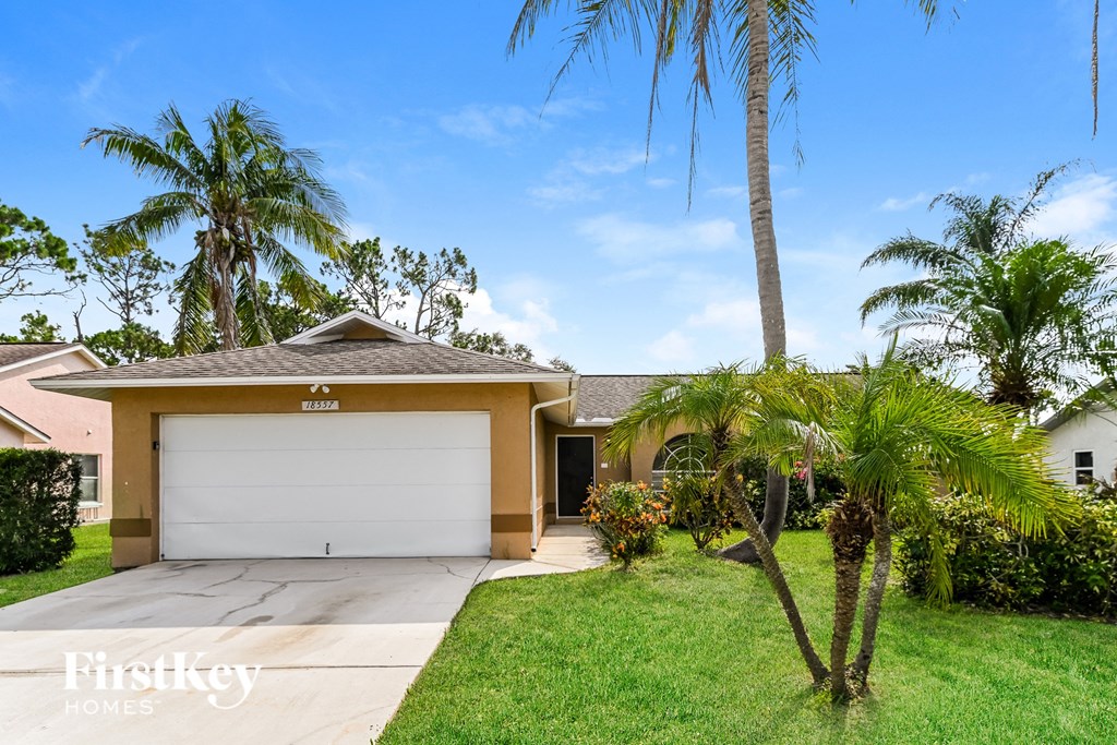 a home with palm trees and a driveway and a garage door