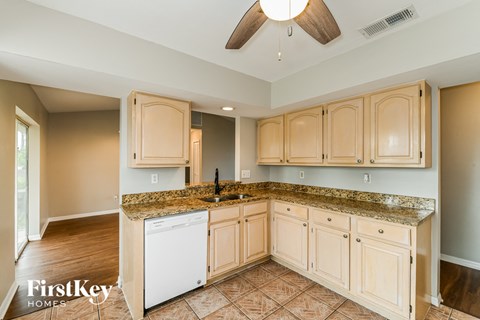 a kitchen with white cabinets and granite counter tops