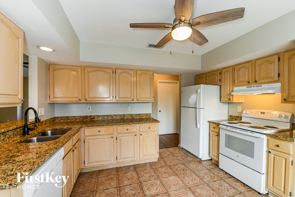 a kitchen with white appliances and granite counter tops