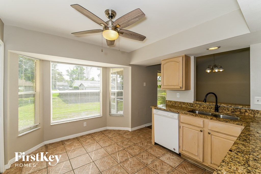a kitchen with a large window and a ceiling fan