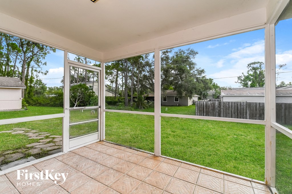 a view of the backyard from the patio of a home with glass doors