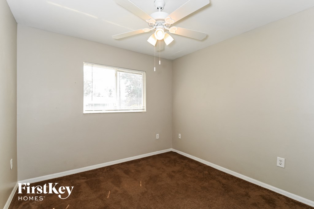 a bedroom with a carpeted floor and a ceiling fan