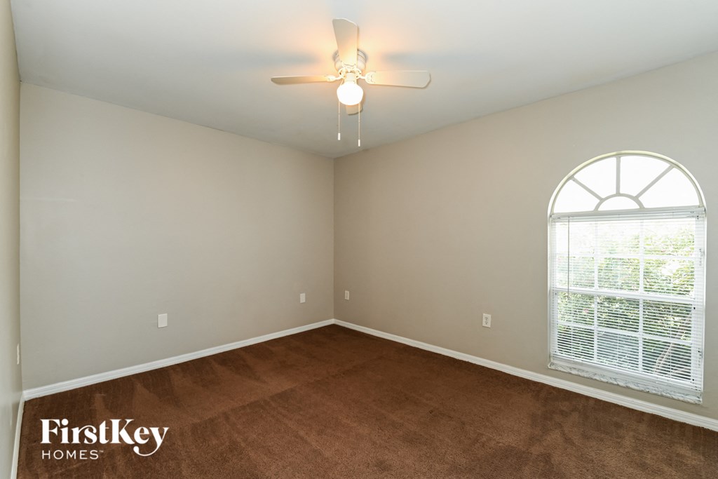 a bedroom with a ceiling fan and a window