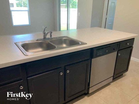 A kitchen with a sink and a FirstKey Homes logo.