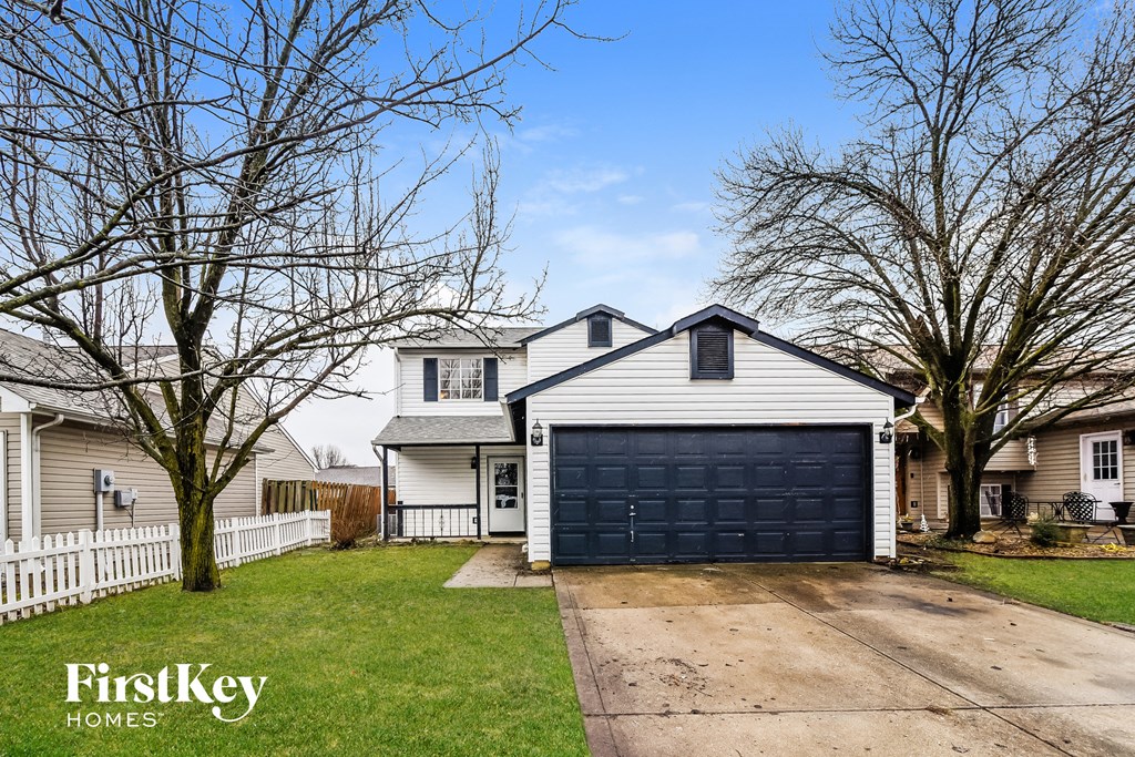 a white house with a black garage door