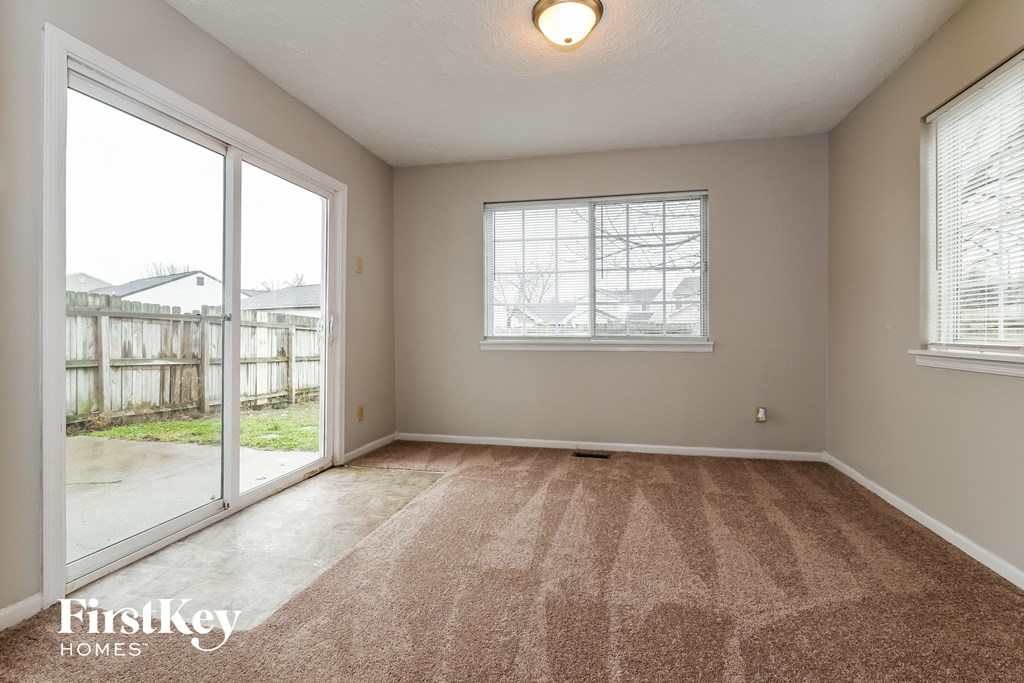 an empty living room with a sliding glass door and a window