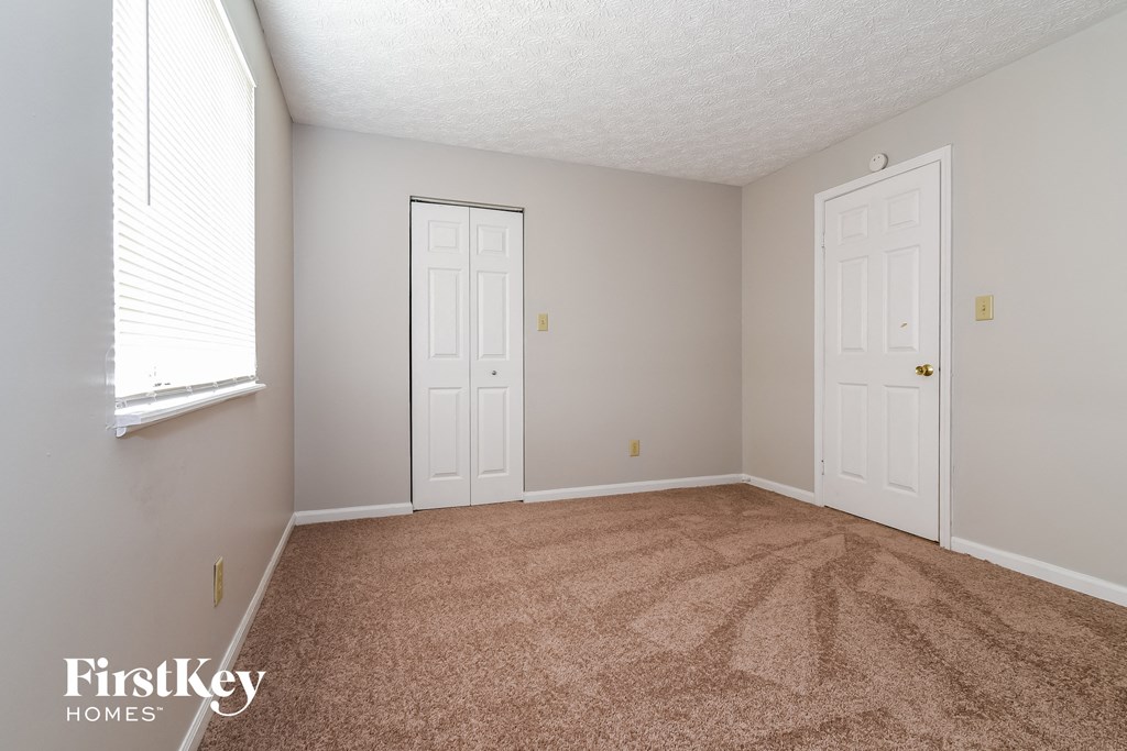 a bedroom with a carpeted floor and two white doors