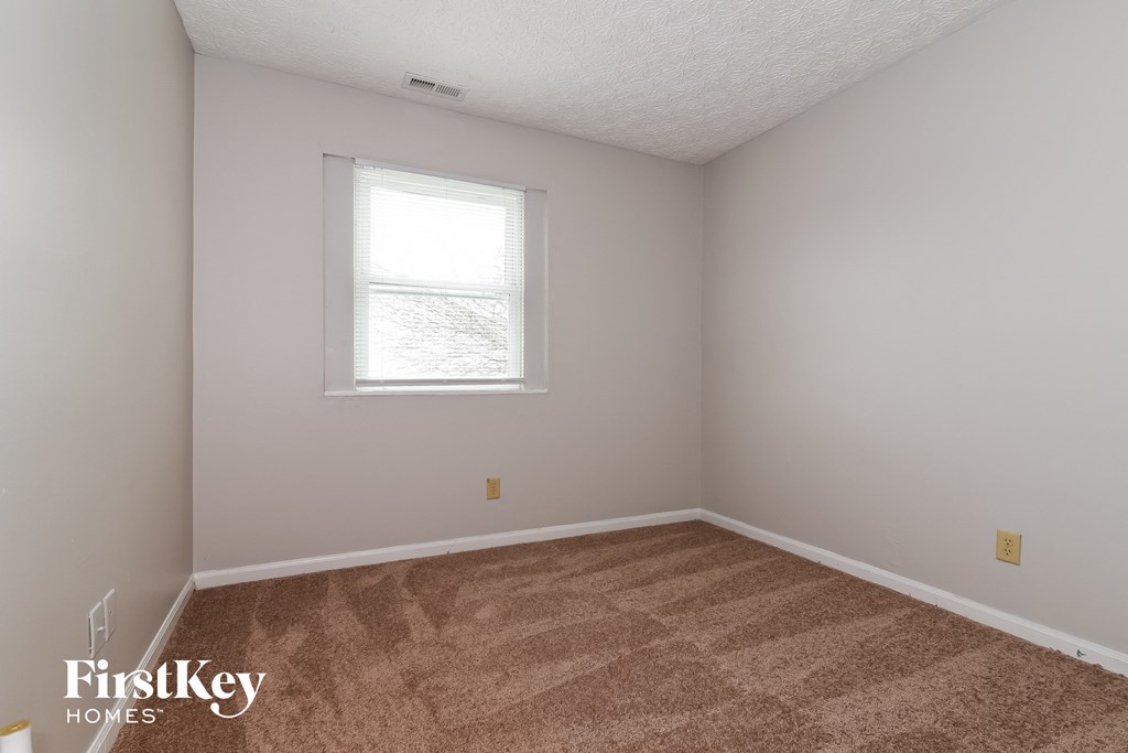 a bedroom with a carpeted floor and a window