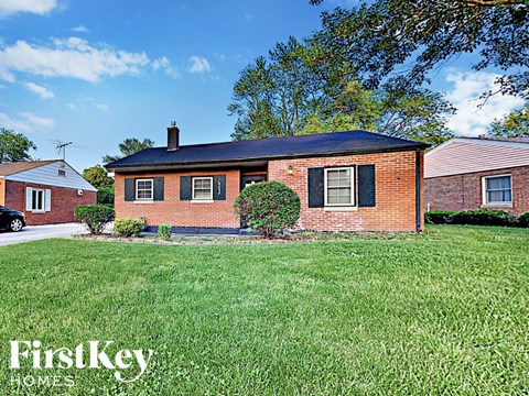 a small brick house with a yard in front of it