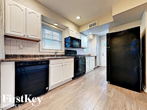 a kitchen with black appliances and white cabinets