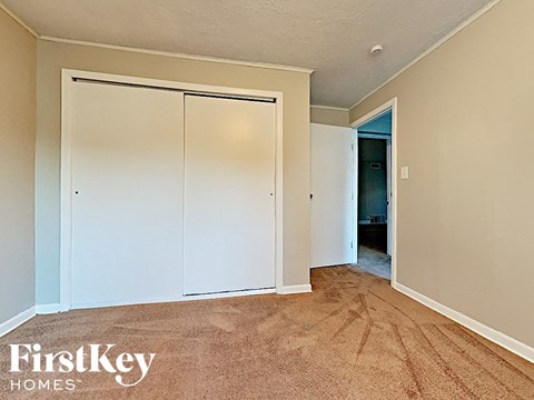 a bedroom with white closets and a carpeted floor