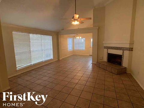 A living room with a fireplace and a tiled floor.