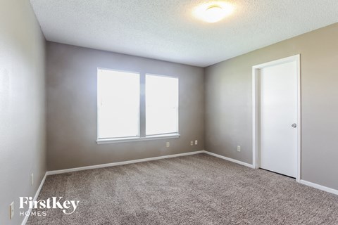 a bedroom with a carpeted floor and two windows