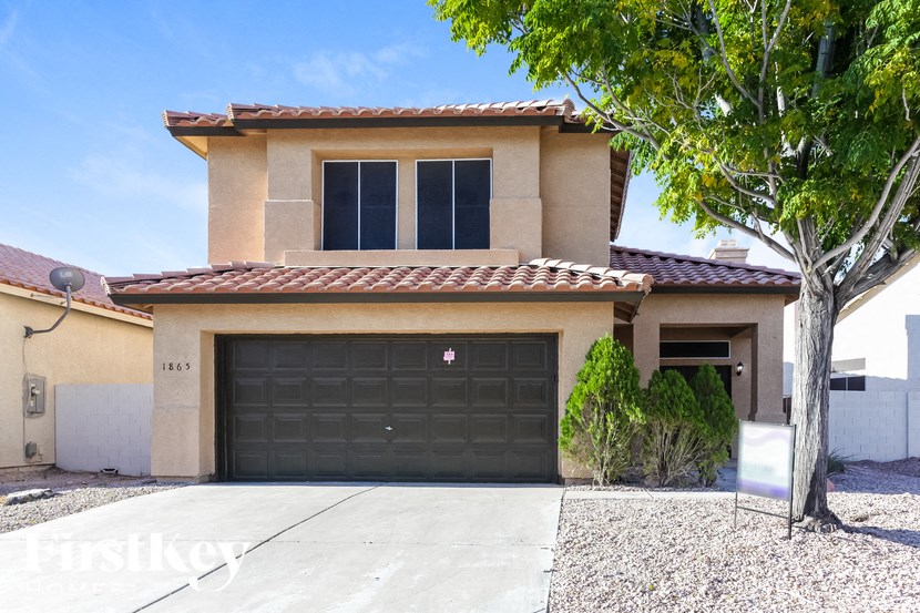 A house with a garage door that has a red logo on it.