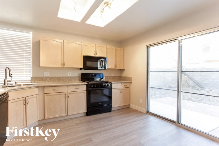 A kitchen with wooden cabinets and black appliances.