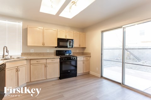 A kitchen with wooden cabinets and black appliances.