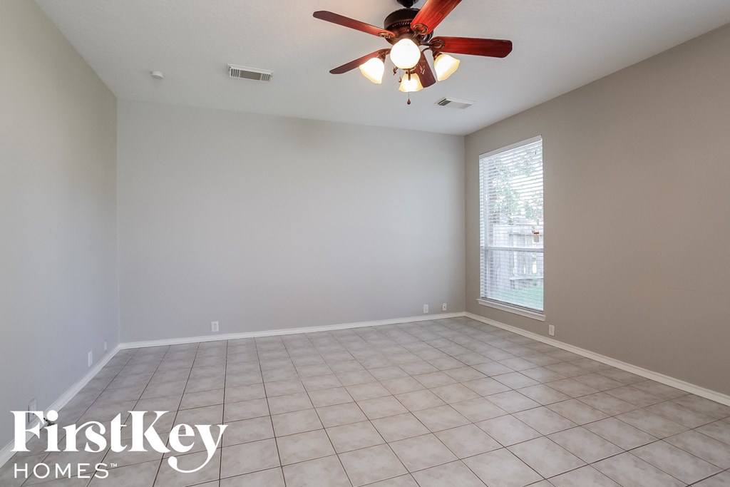 a clean and empty living room with a ceiling fan