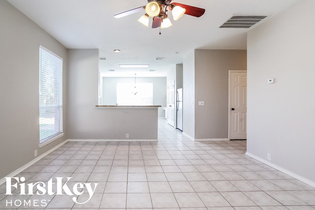 an empty kitchen and living room with a ceiling fan