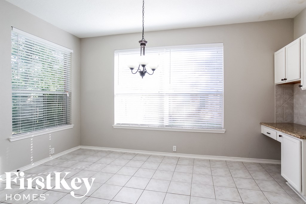 a kitchen and dining room with a large window and a chandelier