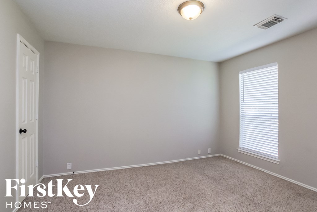 the upstairs bedroom has a carpeted floor and a large window