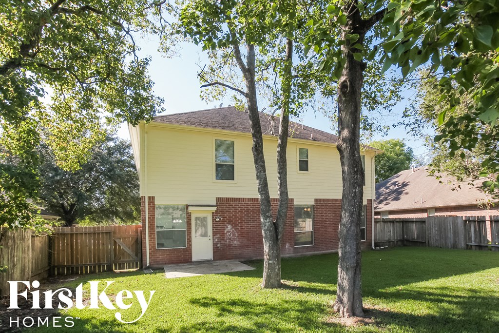 a yellow house with a yard and trees
