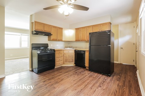 A kitchen with wooden cabinets and black appliances.