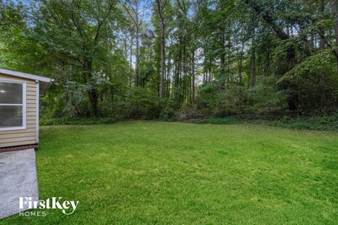 A backyard with a grassy area and a shed.
