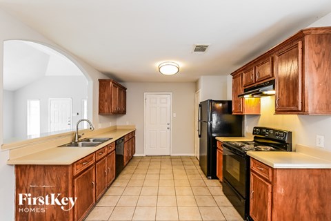 A kitchen with wooden cabinets and black appliances.