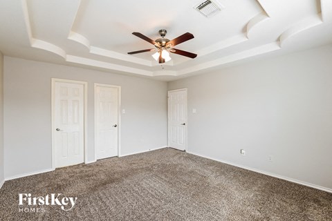 a living room with carpet and a ceiling fan