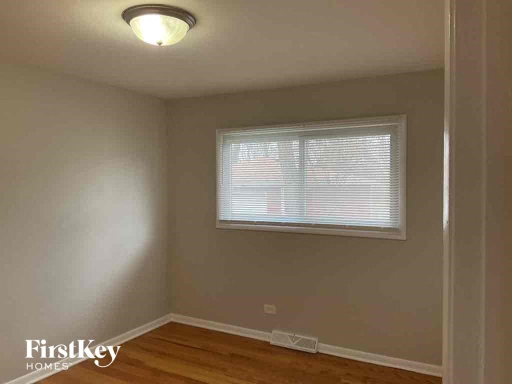 an empty room with a window and wooden floors