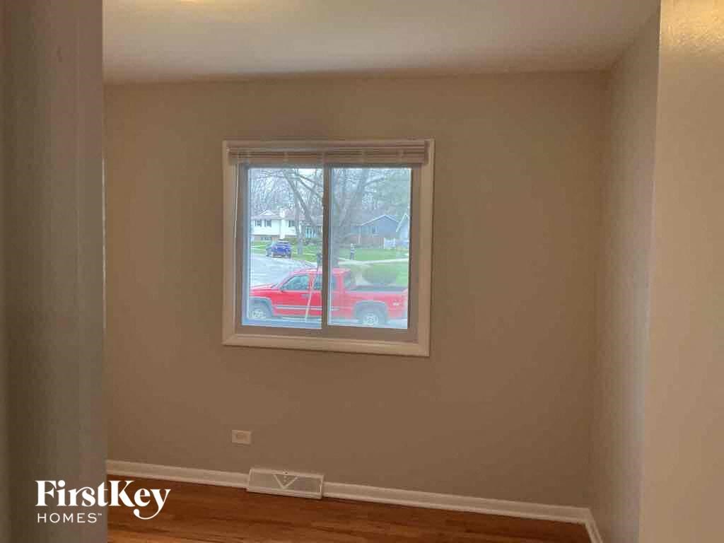 an empty room with a window and a red car in it