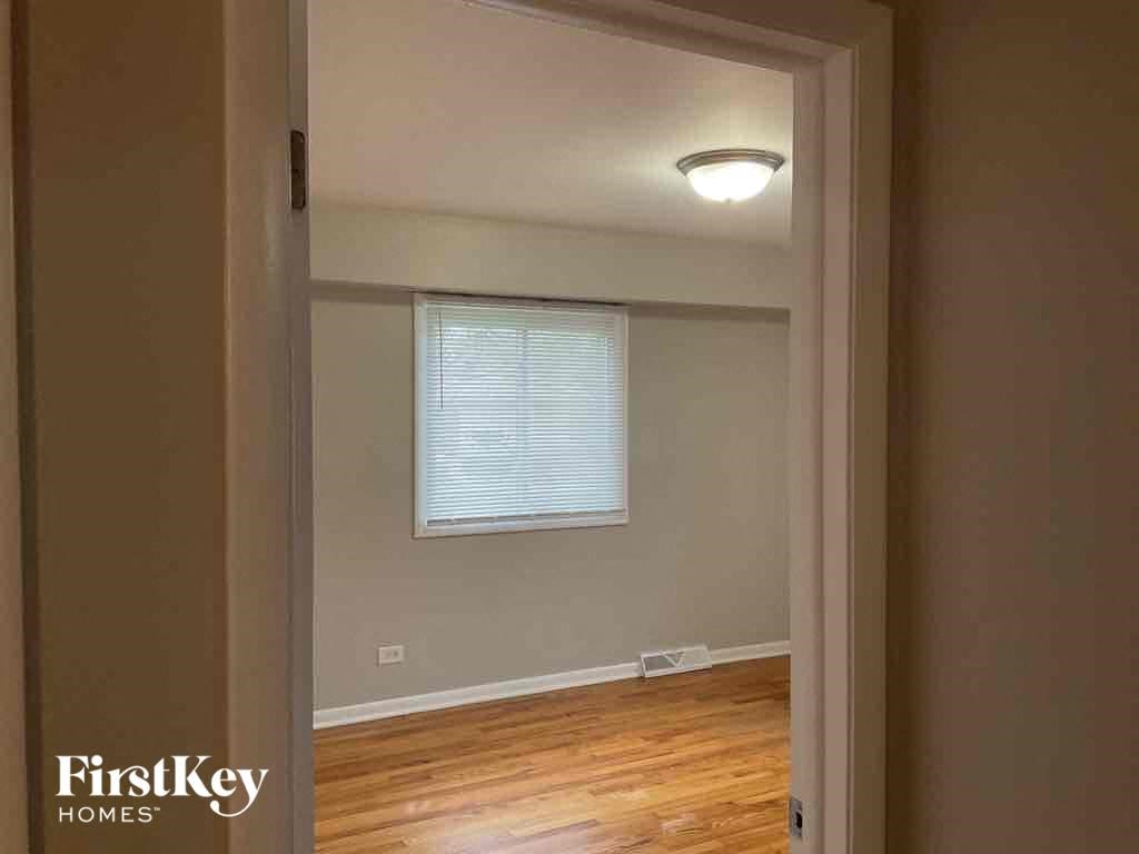an empty room with a window and wooden floors